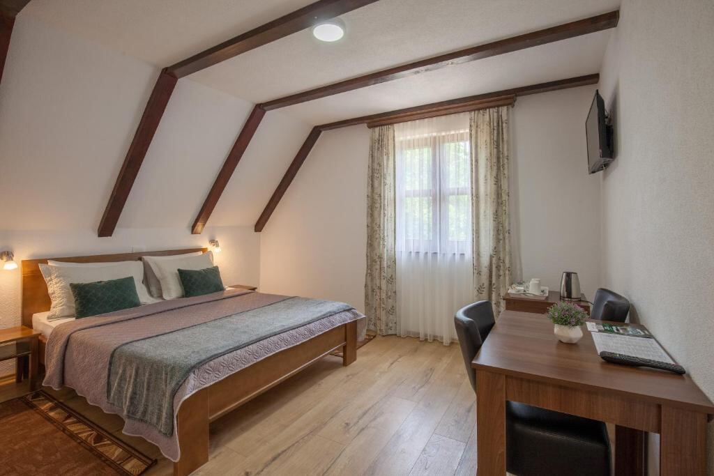 Room with wooden beams, double bed and desk - Rooms Imperial House